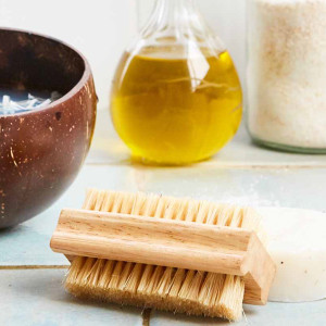 Natural tampico nail brush sitting on a blue tiled bathroom counter